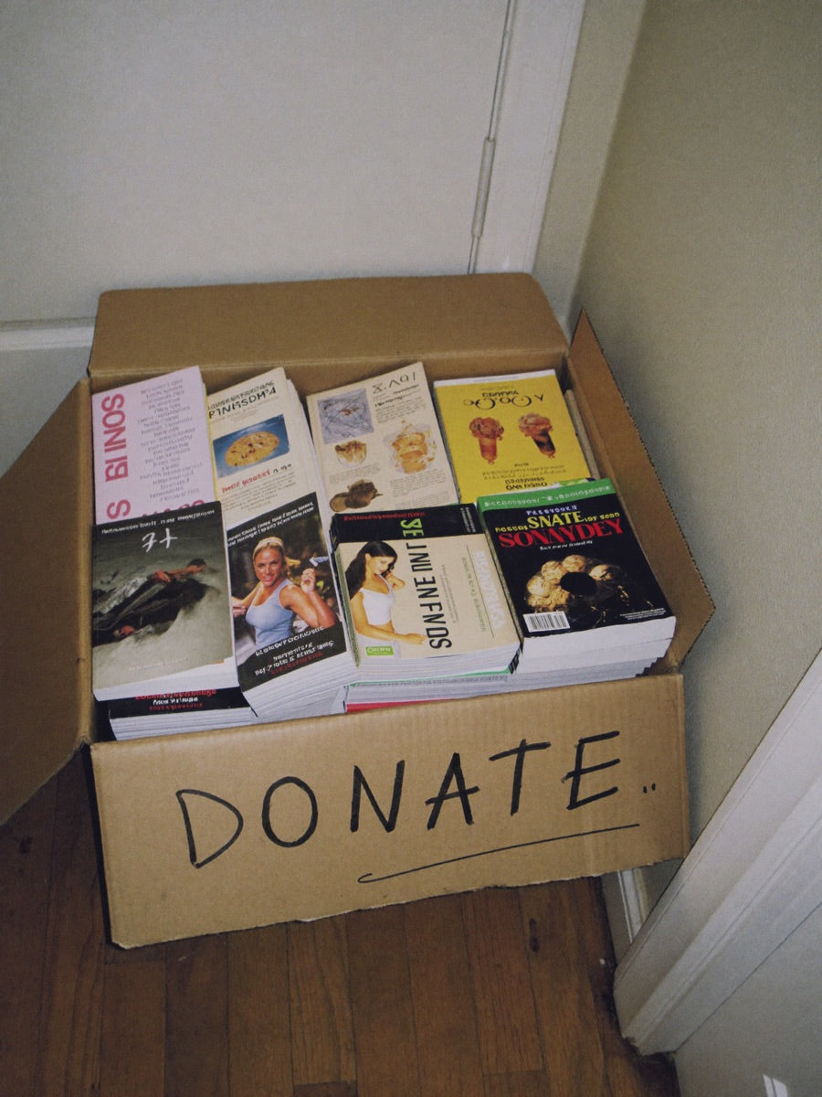 A cardboard box labeled donate, filled with old diet books and programs
